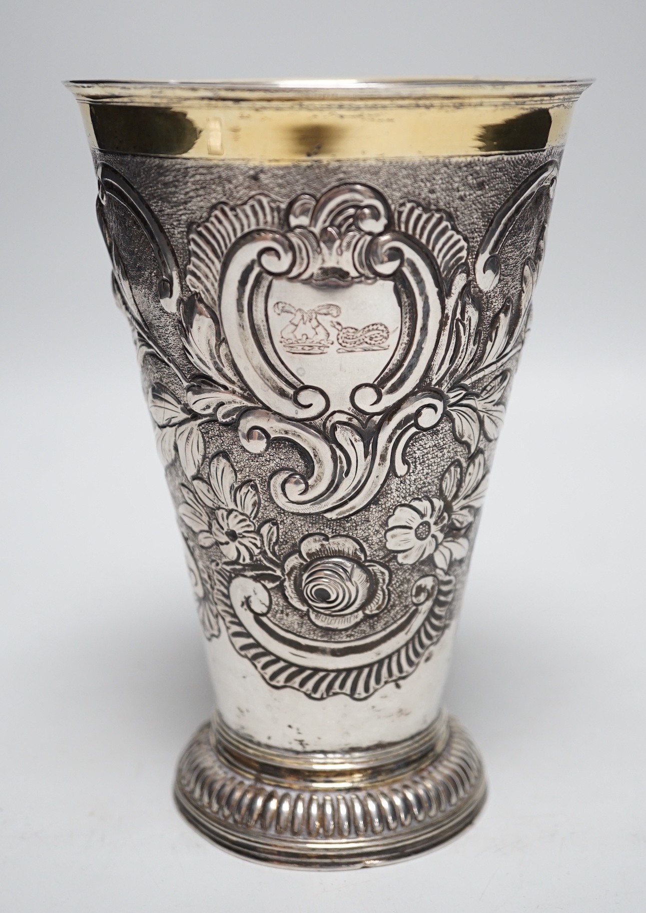 A 19th century Swiss? embossed parcel gilt white metal flared vase, maker's mark AWM, engraved with two armorials, height 17cm, 10.8oz.